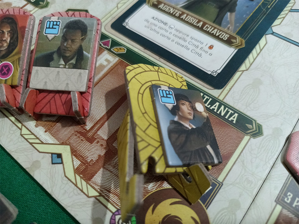 Una scelta totalmente inspiegabile… in foto potete osservare il supporto tanto criticato: poco ergonomico da spostare sulla plancia di gioco, con il segnalino su di esso spesso propenso a cadere negli spostamenti e con il supporto stesso che si smonta continuamente.Fa specie poi vedere che per il singolo standee di Cthulhu abbiano optato per il classico supporto in plastica, scelta che sarebbe stata molto apprezzata se estesa a tutto il gioco: magari utilizzando basette colorate per identificare gli agenti dei giocatori e un token in più per segnalare gli agenti che diventano redivivi (una situazione di gioco integrata con i token degli agenti double face).